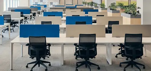 Modern open-plan office space featuring clean workstations, ergonomic chairs, and sanitized carpets provided by professional office cleaning services in Lincoln, NE.